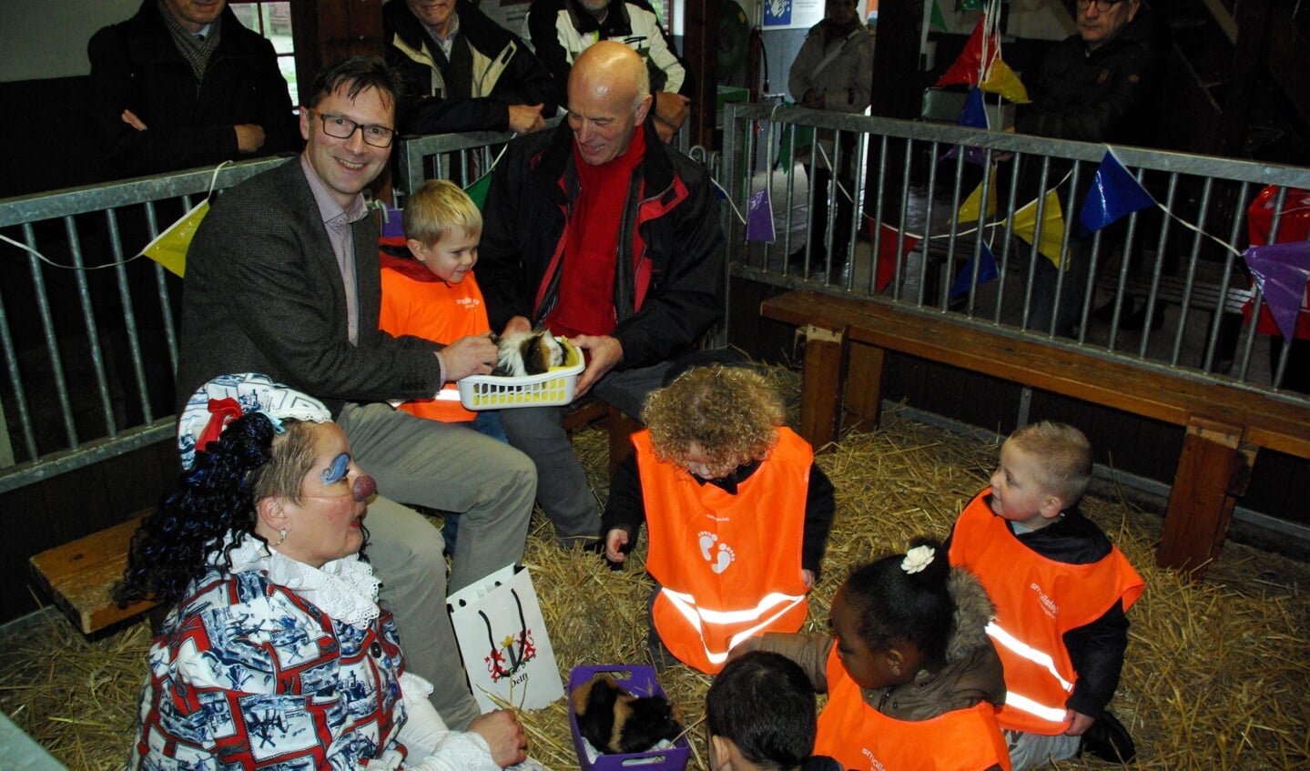 Wethouder Stephan Brandligt en Henk den Boer vieren de goede afloop tussen de kinderen, cavia's en clown Delfie. (foto: Jesper Neeleman)