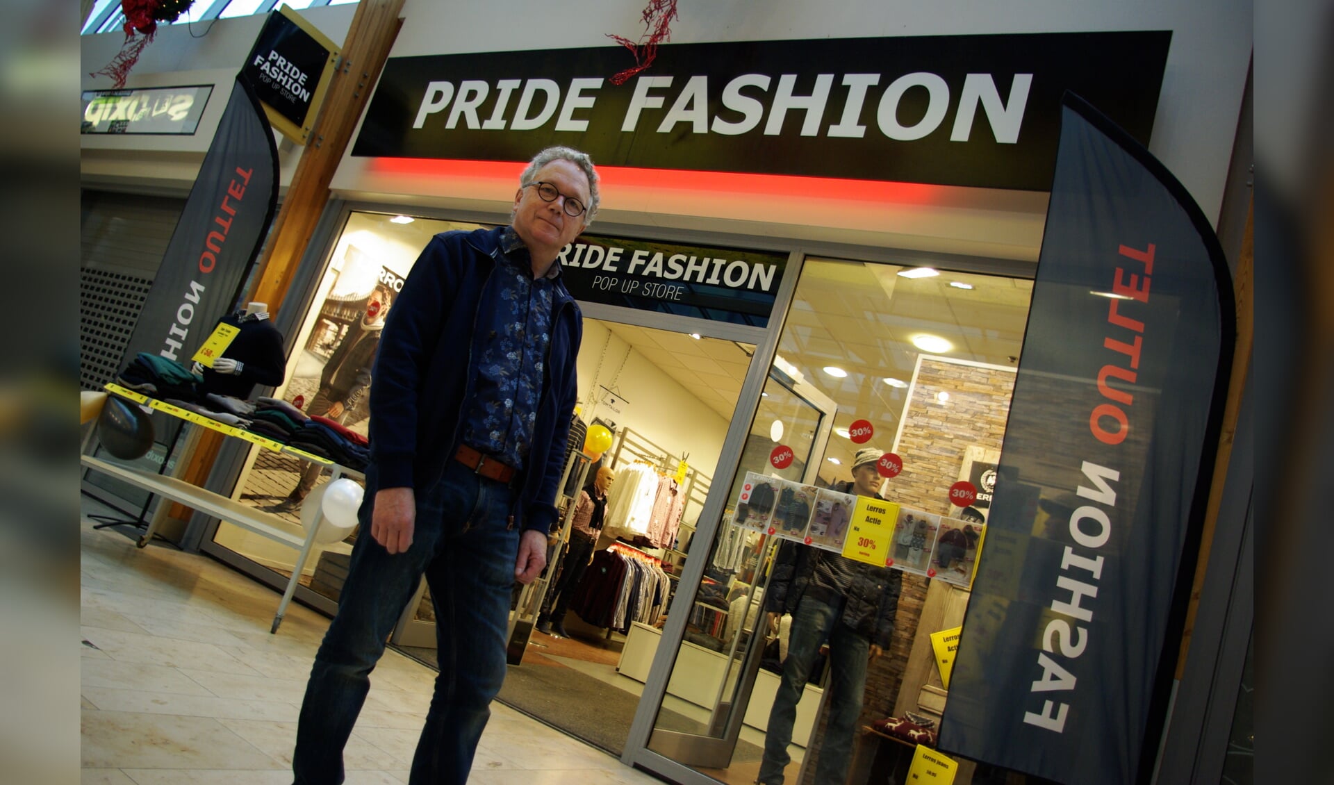 Ailko Kok, met pal achter hem de pop-up herenmodezaak Pride Fashion en de door RODI verzorgde gevelreclame. 