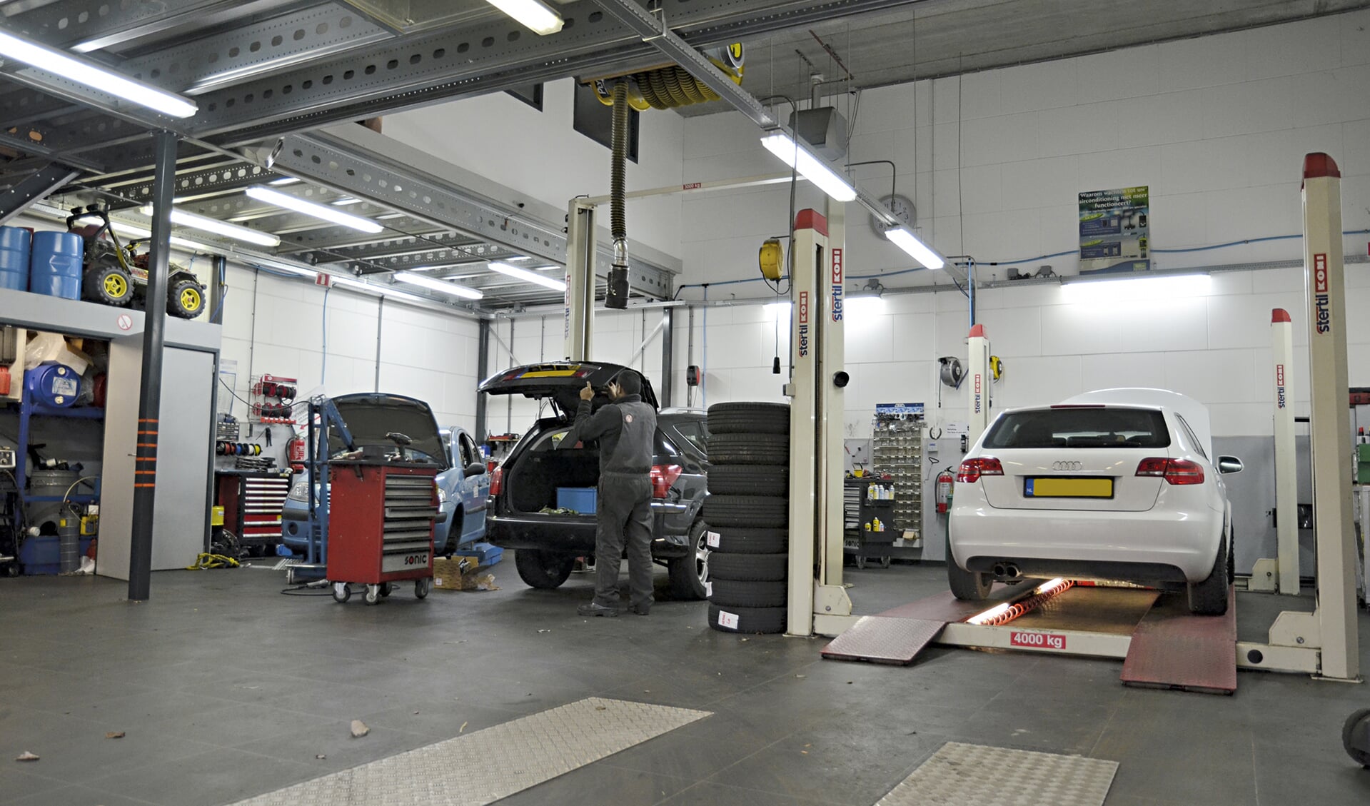 Het bedrijfspand van Autobedrijf Harnaschpoort, met drie bruggen voor het onderhoud of reparatie aan uw auto.