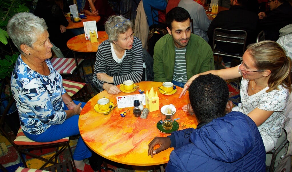 Het was woensdagmorgen volle bak bij Uit de Kunst, waar enkele vluchtelingen met veel Delftenaren in gesprek gingen. (foto: Jesper Neeleman)