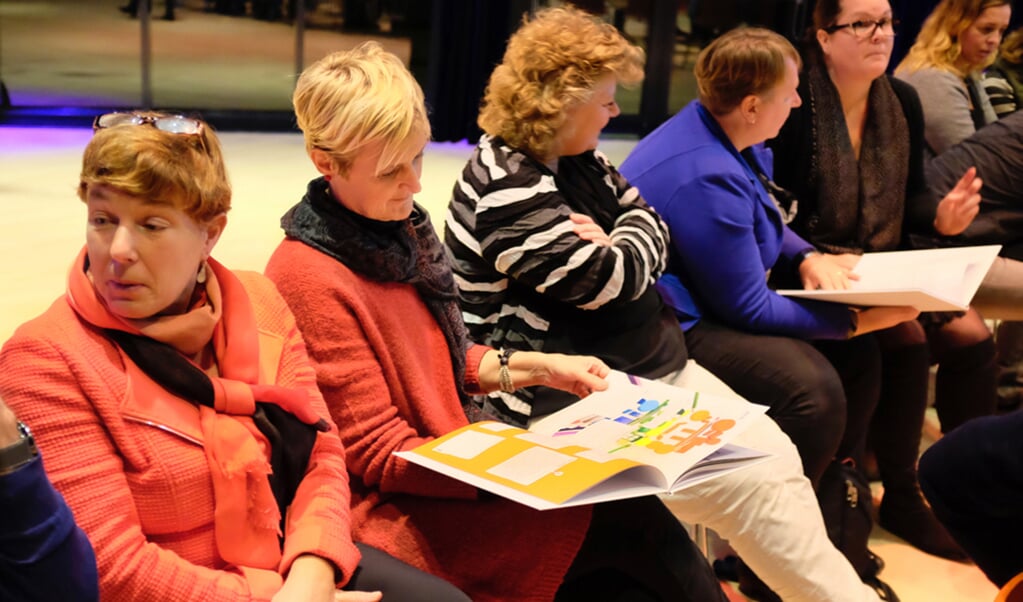 Leerkrachten en directie van de Cultuurhelden-scholen bladeren door Het Grote Cultuurheldenboek. (foto: Wolf Brinkman)