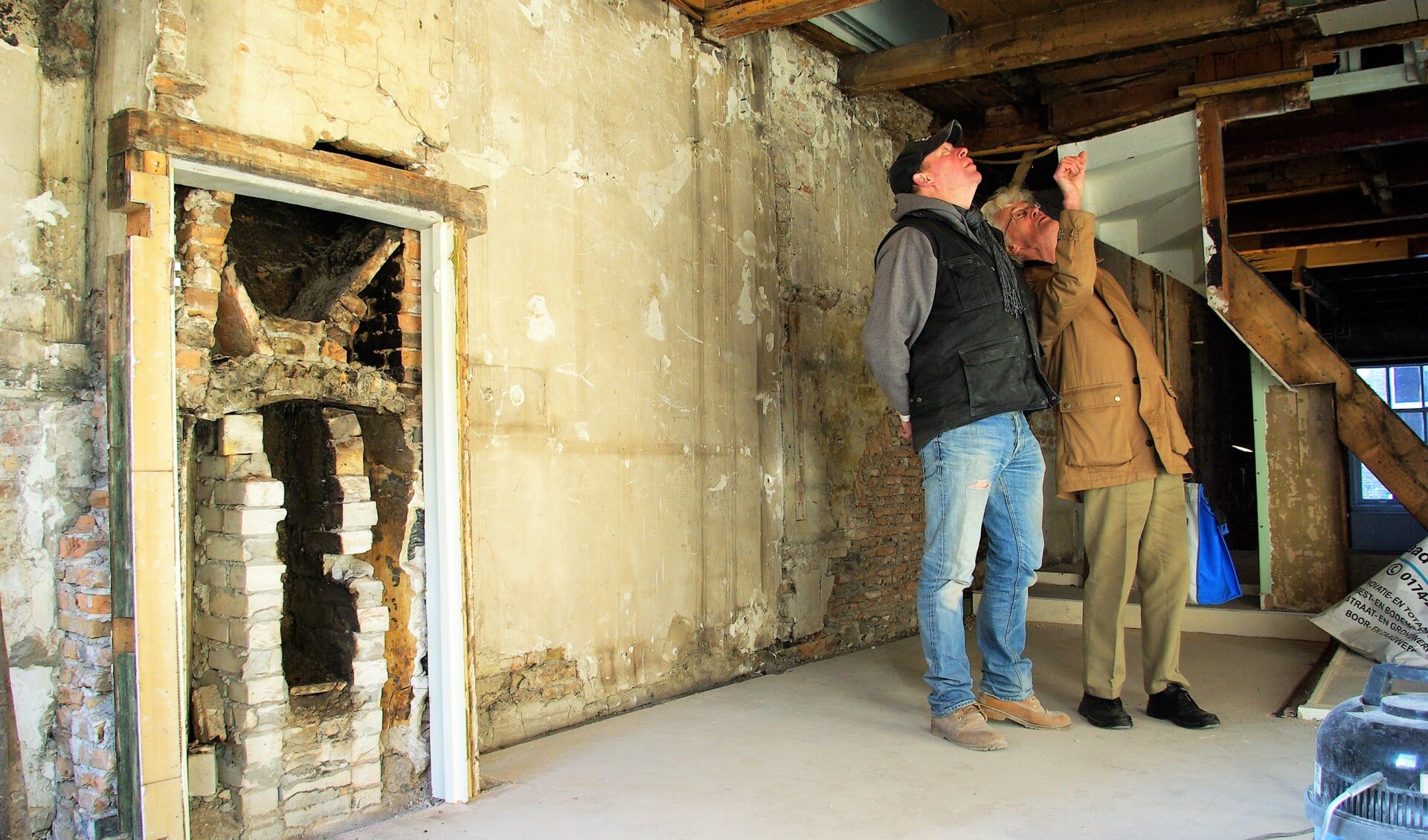 Christiaan Baljé (links) en Willem Annema vergapen zich aan de oude moerbinten op de eerste verdieping. Links de stookplaats, rechts de gammele trap. (foto: Jesper Neeleman)