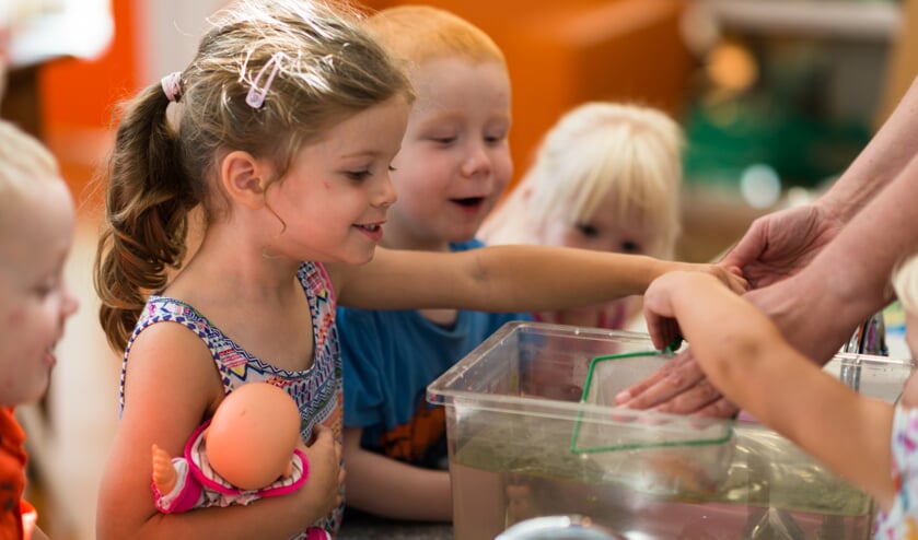 Kinderen op KDV Joriaantje verschonen het aquarium.