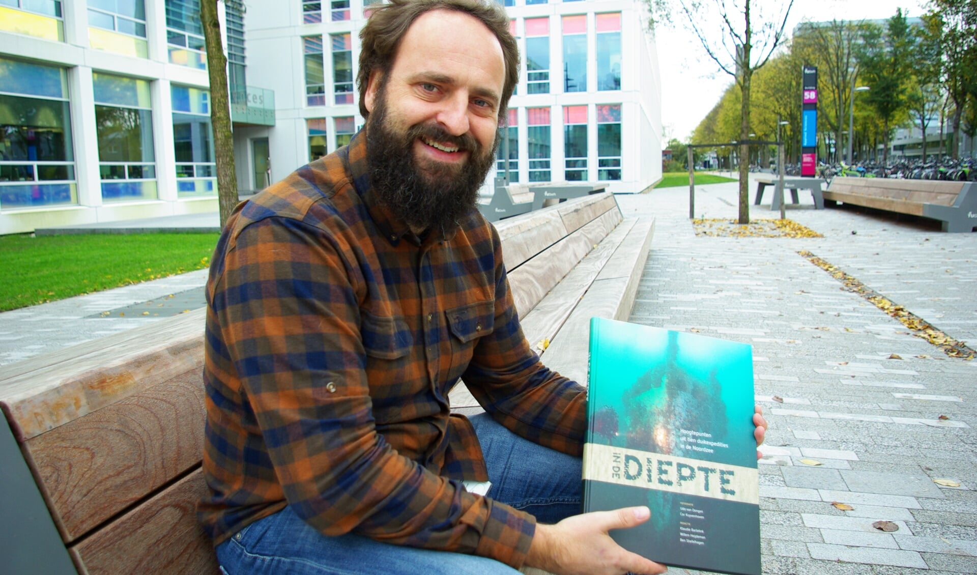 Udo van Dongen showt het boek 'In de diepte', waarvoor hij talloze foto's maakte. 