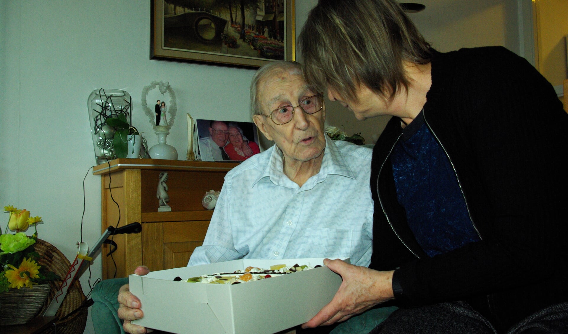 De 98-jarige Delftenaar Frans Etienne kreeg een taart, een boek en bloemen, maar vond de vol gestroomde huiskamer toch wel het mooist. (foto: Jesper Neeleman)