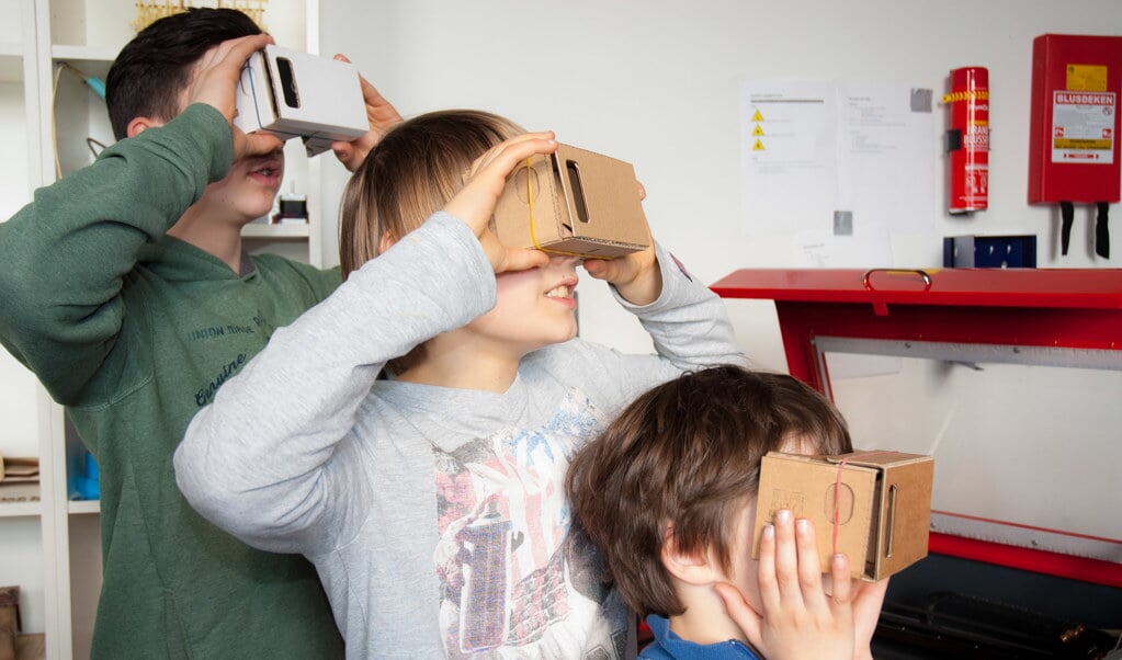 Kinderen graveren cardboardbrillen met de lasersnijder in Maakbaar.