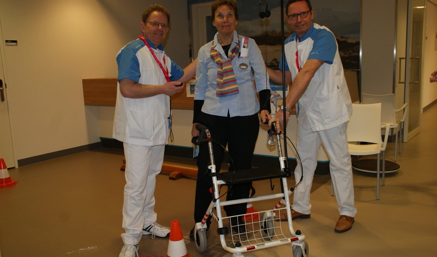 Een deelnemer aan de Rollator Race met twee medewerkers van het ziekenhuis.