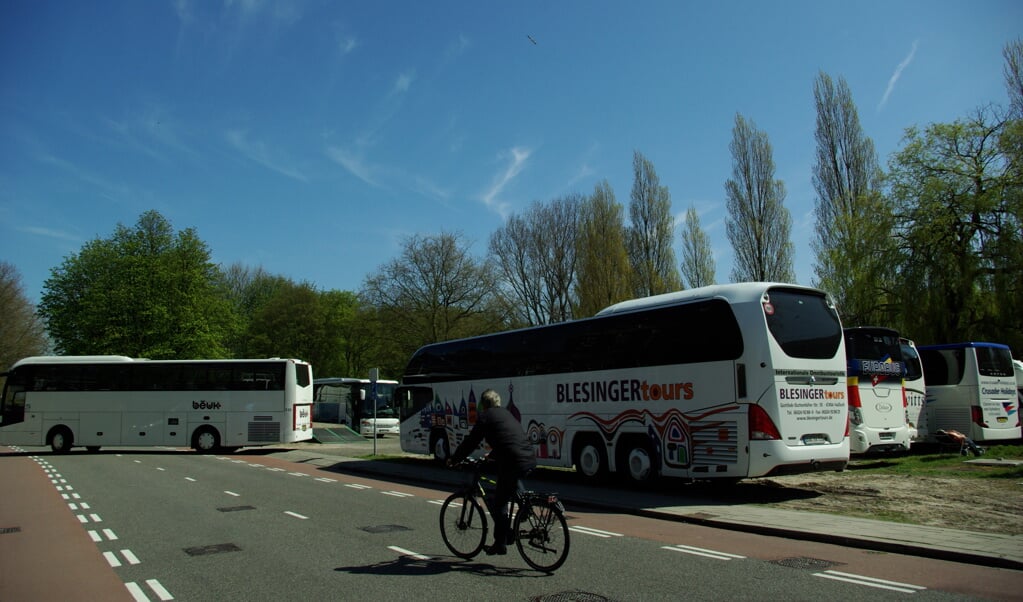 Het Zuidplantsoen op donderdagmiddag: een touringcar steekt een volle parkeerplaats op, een fietser wil er op de rijbaan langs en uiterst rechts geniet een chauffeur met ontbloot bovenlichaam van de voorjaarszon. (foto: Jesper Neeleman)
