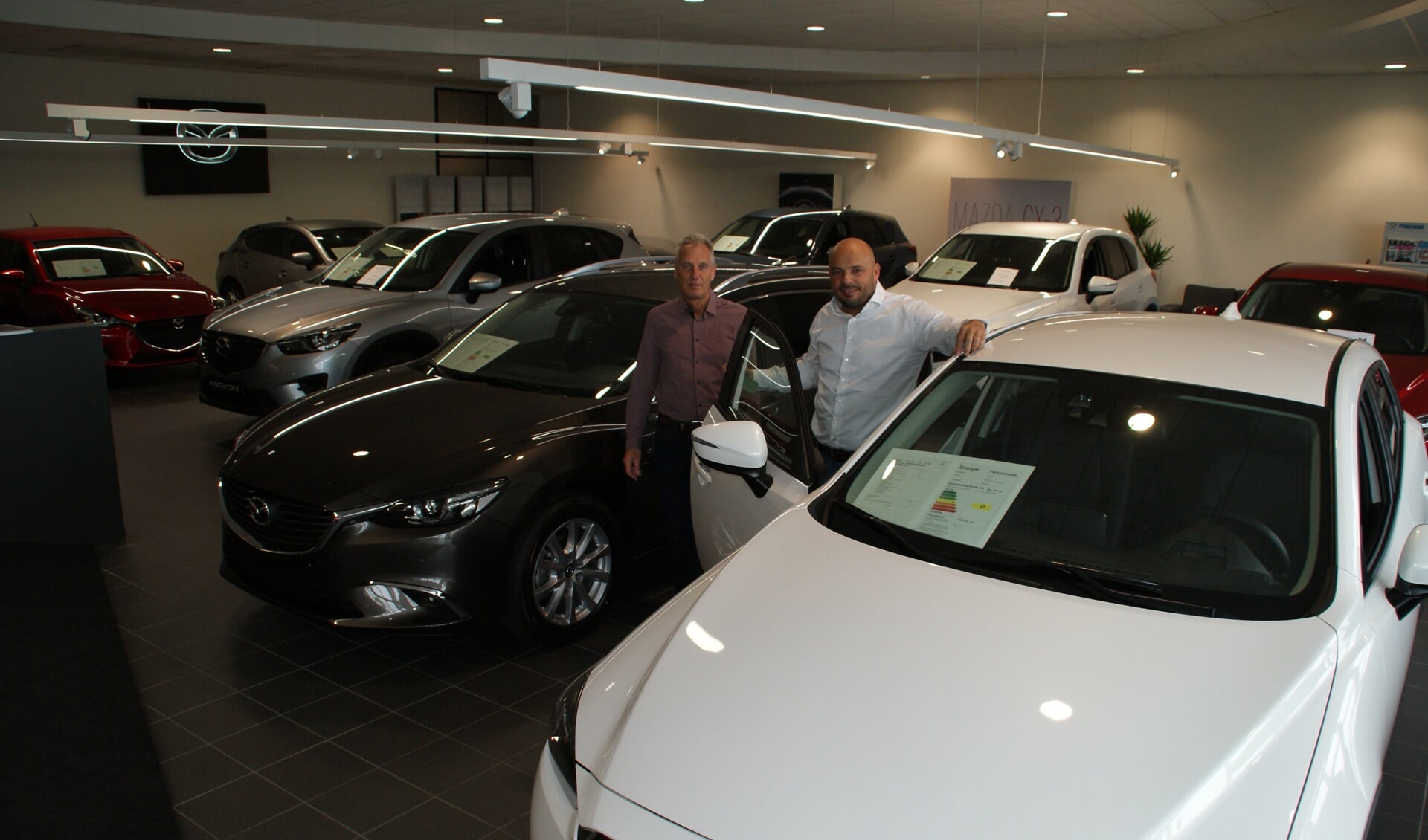 Directeur Dito Tomas Mollema (rechts) en verkoopadviseur Paul Staal in de showroom van Mazda Haagstad in Den Haag.