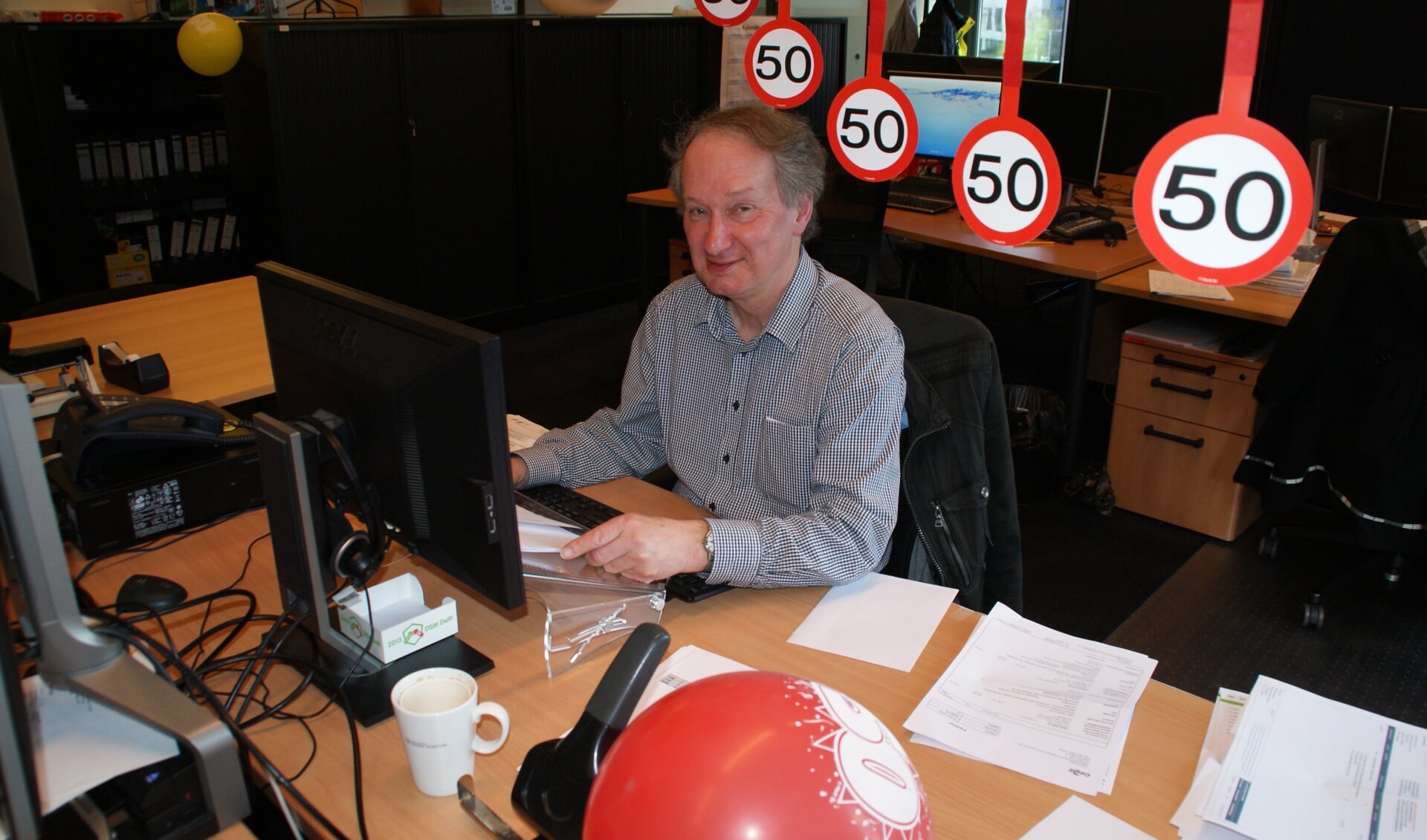 Jubilaris Dick van Werkhoven op zijn werkplek op het kantoor van DSM Gist.