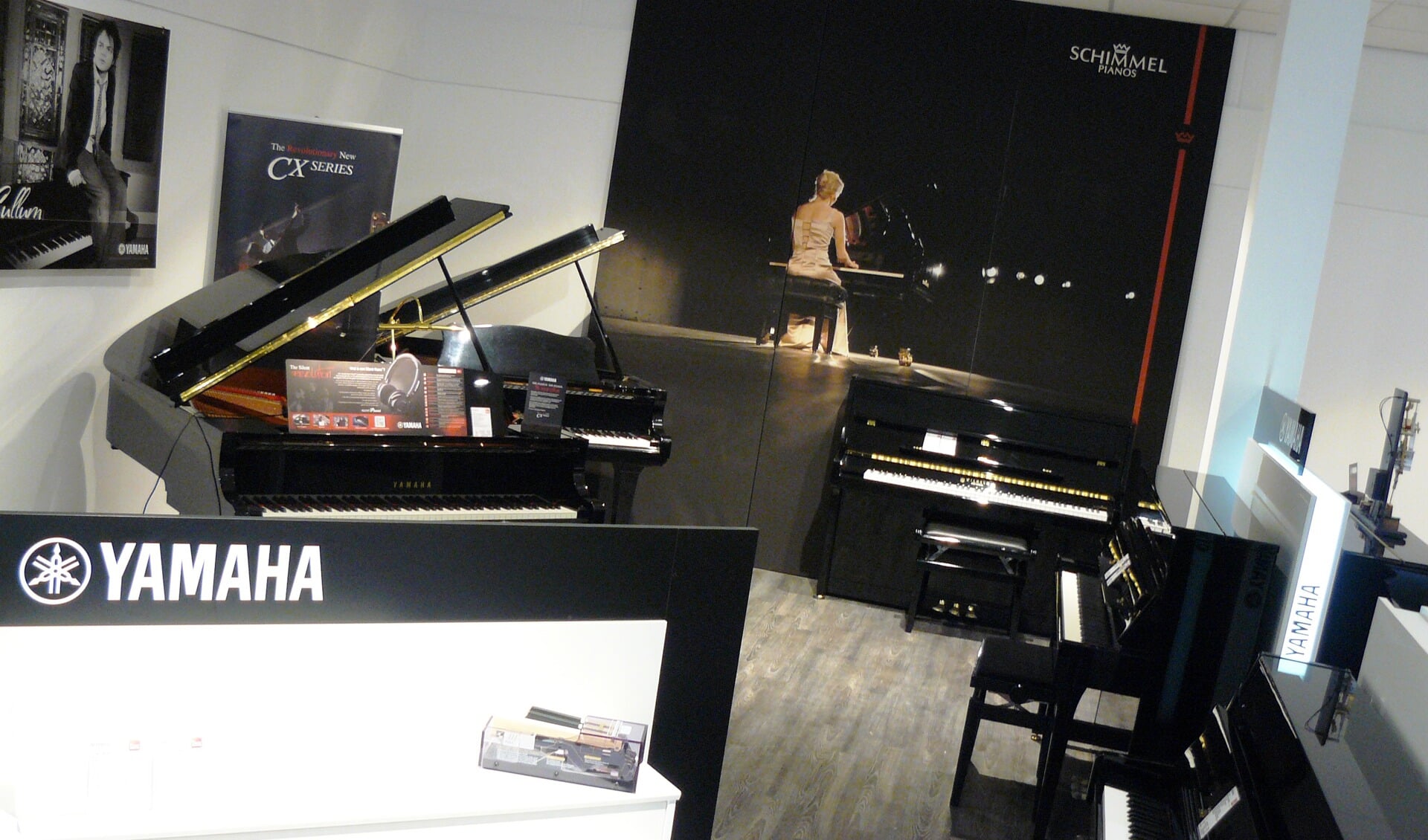 De goedgevulde showroom van Clavis Piano's. 