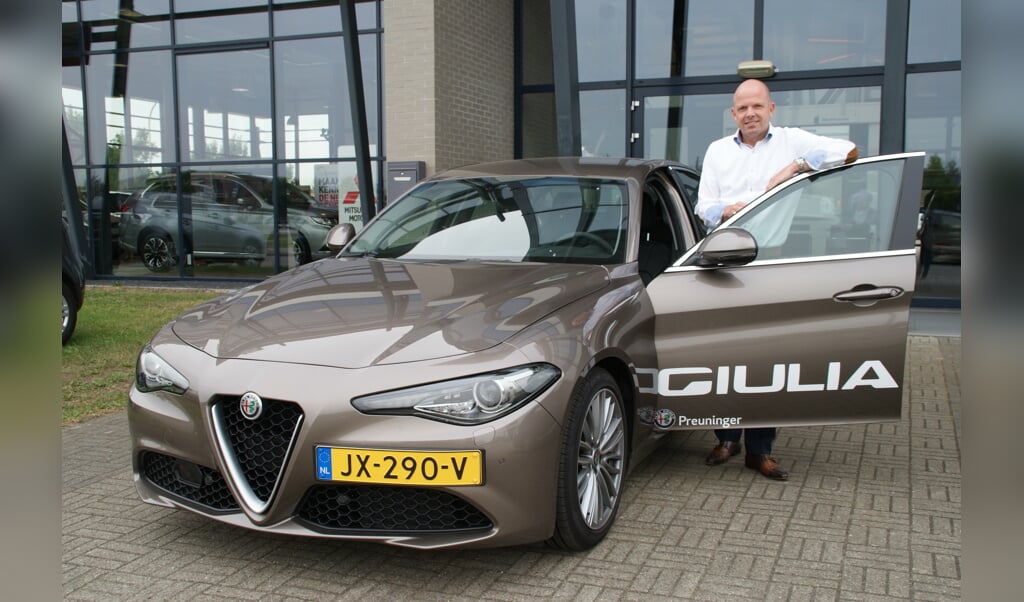 Robert den Toom van Alfa Romeo bij de nieuwe Giulia voor de hoofdingang van Preuninger Haagland.