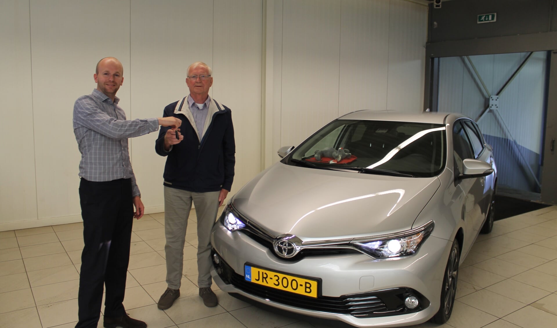 Verkoper Joep Pezie van Toyota DIGO overhandigt de autosleuteltjes aan de heer Wim van der Knaap.
