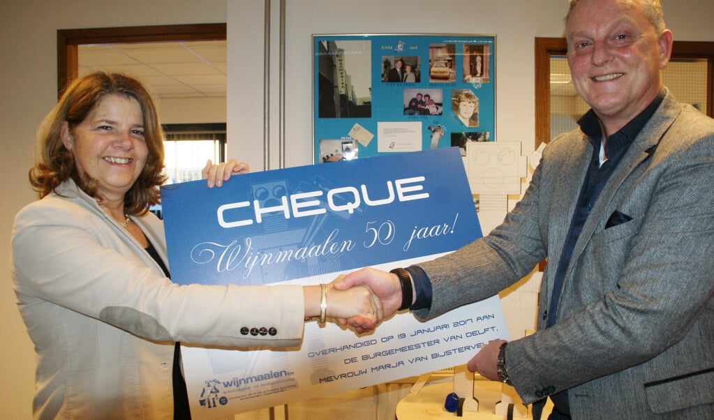 Burgemeester Marja van Bijsterveld krijgt de cheque overhandigd door Peter Wijnmaalen.