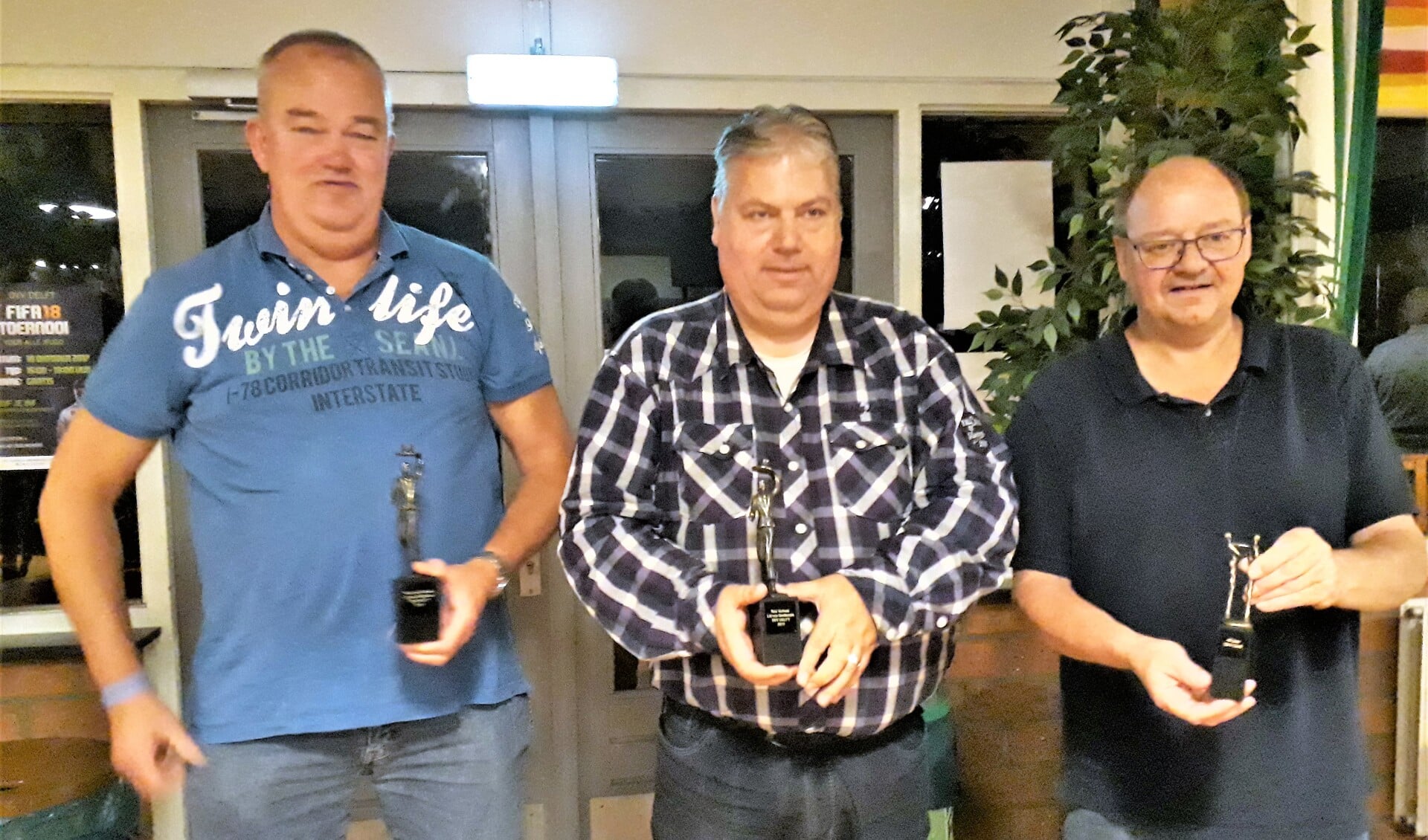 Kees van Kampen (links), Ron Verhaar en Aad van Ruyven (rechts) kregen een eretitel en een bijbehorend beeldje. 