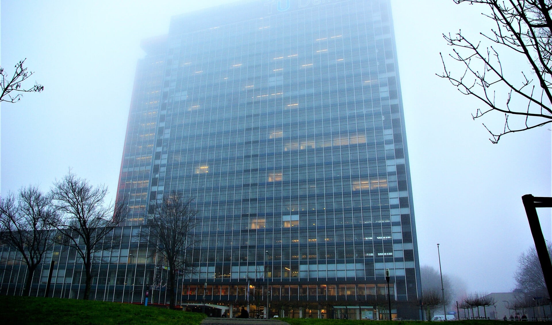 Het EWI-gebouw van de TU Delft, in nevelen gehuld.