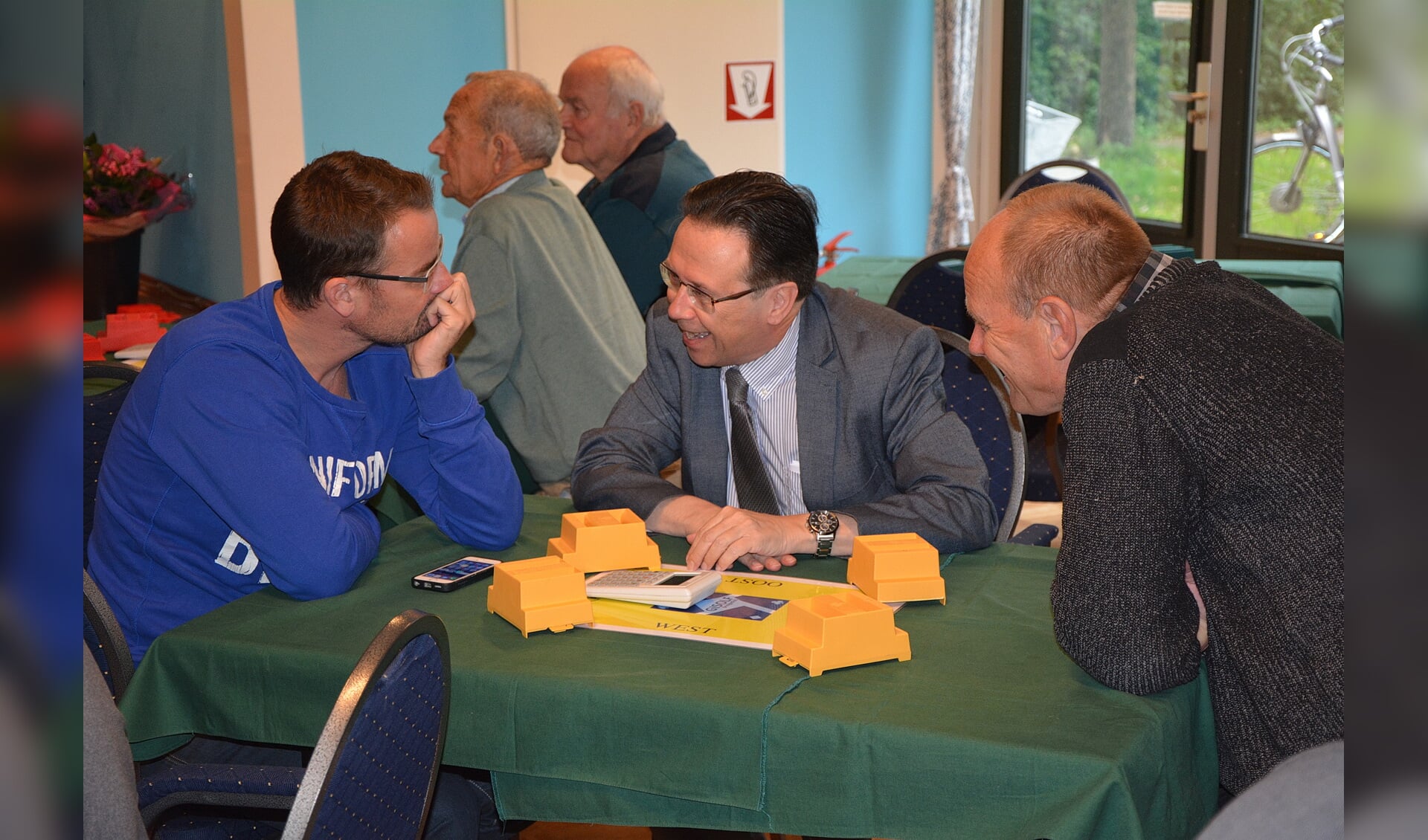 Raimond de Prez (links), Wicher Schreuders en Guus Heemskerk in gesprek tijdens het jubileum van Bridgeclub Gisolf. 