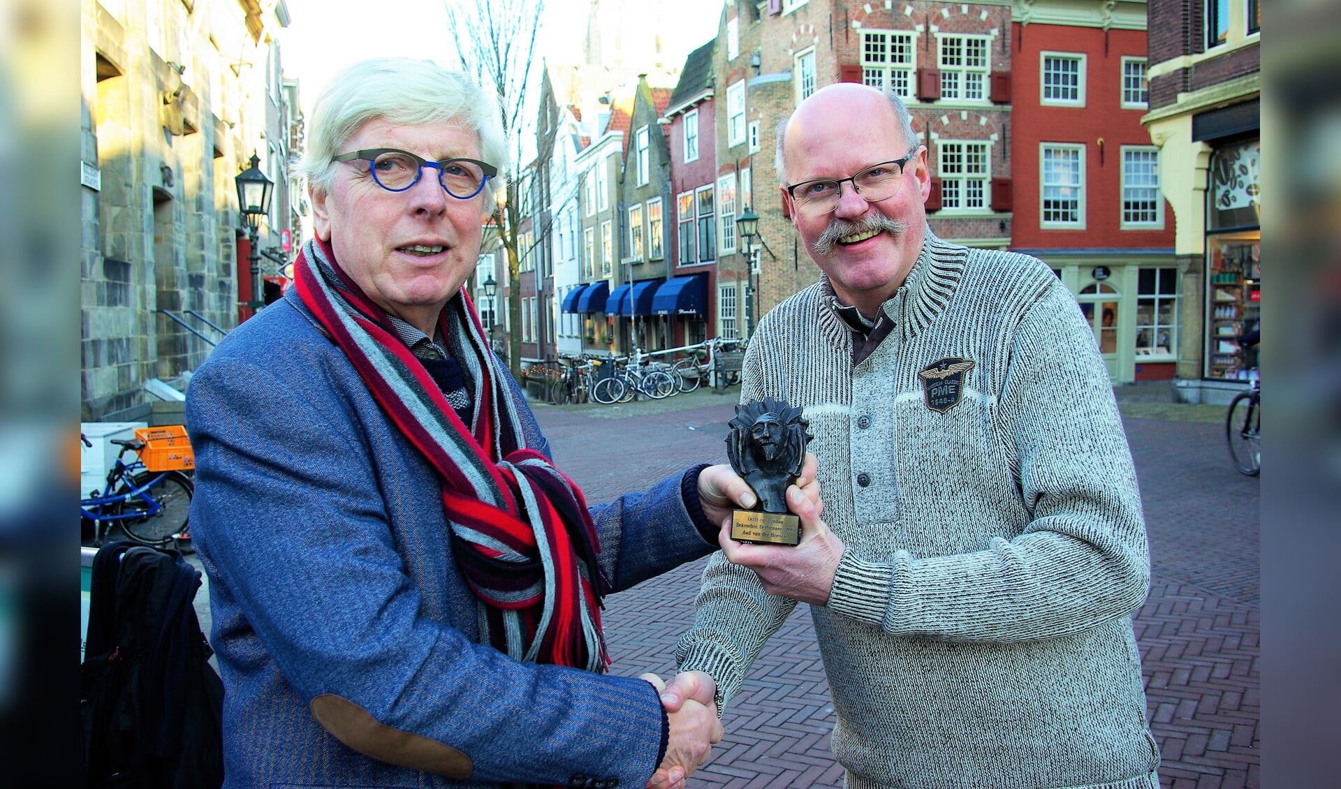 Bekendste Delftenaar 2016 Leo Quack reikt de prijs, een door Loes van der Holst ontworpen bronzen Hugo, uit aan zijn opvolger: Aad van der Hoeven. Aan wie mag Van der Hoeven deze prijs uitreiken? Mail de naam van uw Bekendste Delftenaar naar bekendstedelftenaar@delftopzondag.nl. 