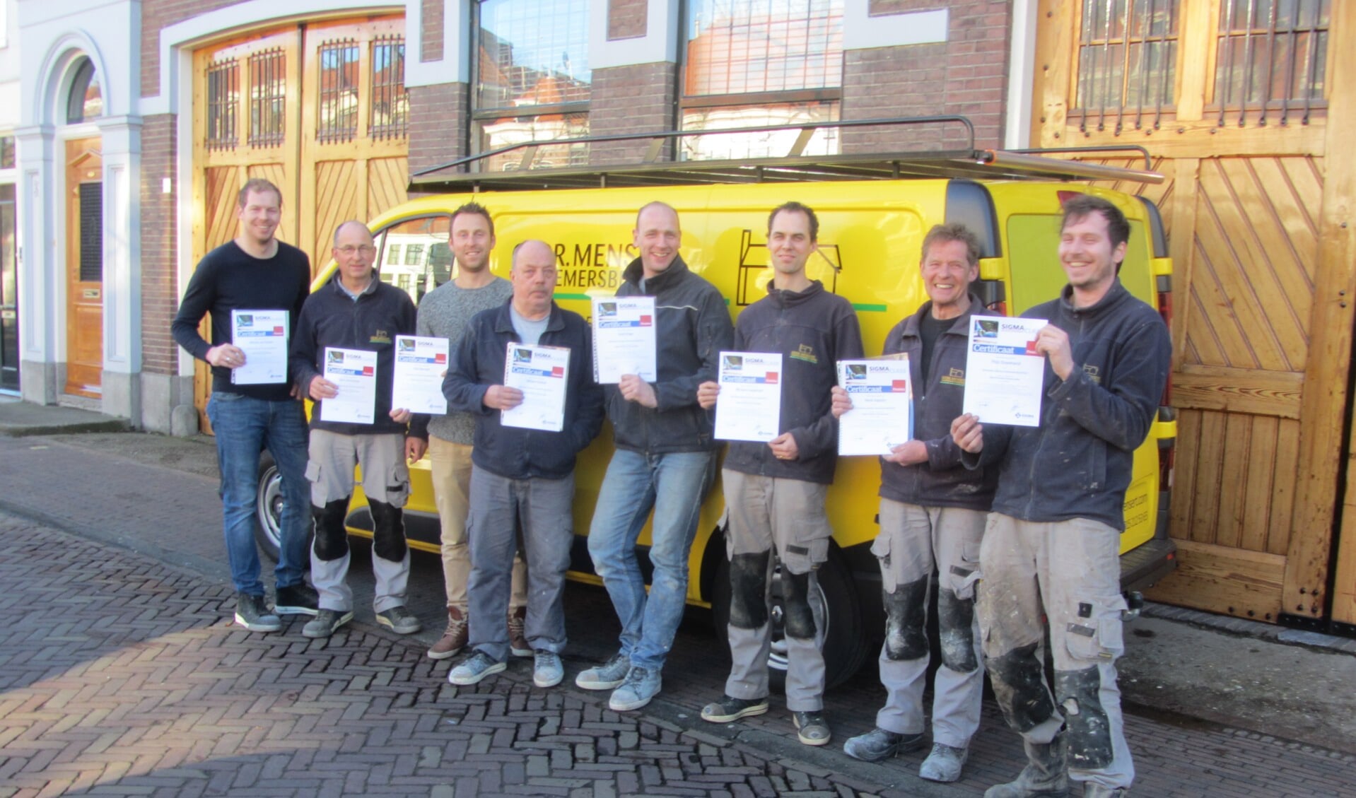 Piet Mensert en zijn medewerkers met de zojuist behaalde certificaten voor de nieuwe bedrijfswagen.