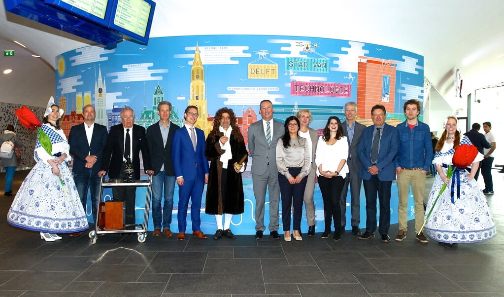 Een klein deel van de aanwezigen poseert bij de technologiewand op het station, met centraal op de foto Ferrie Förster (in het blauw) en rechts van hem Tim van der Hagen (in het grijs). 