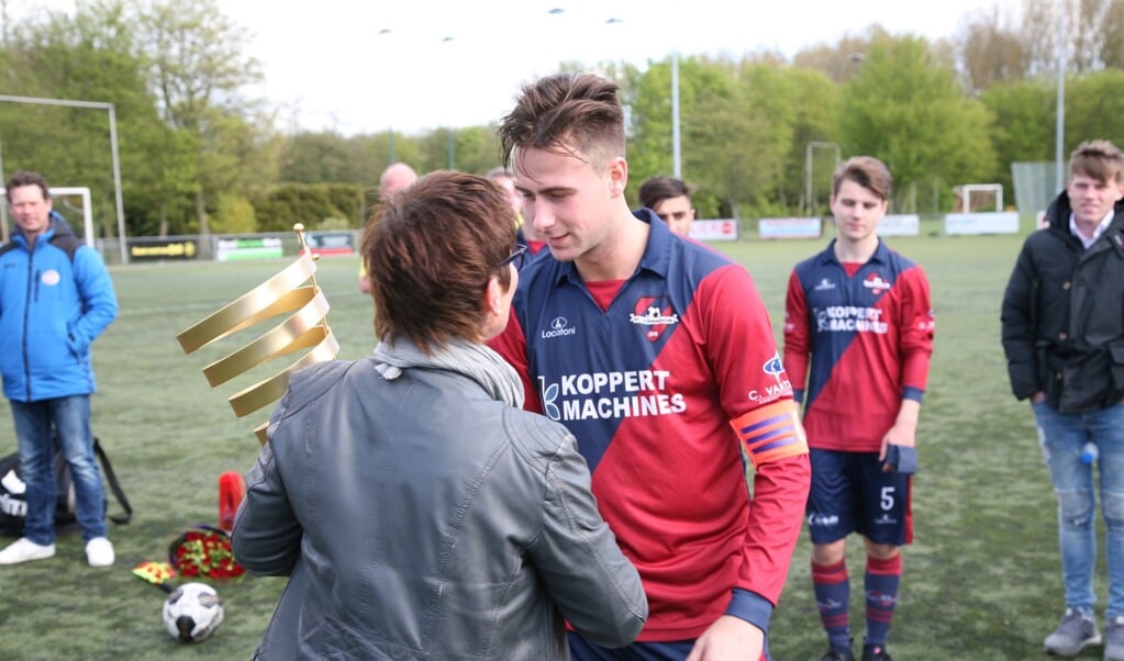 Marrie van Zinnen reikt de prijs uit aan de captain van FC 's-Gravenzande. 