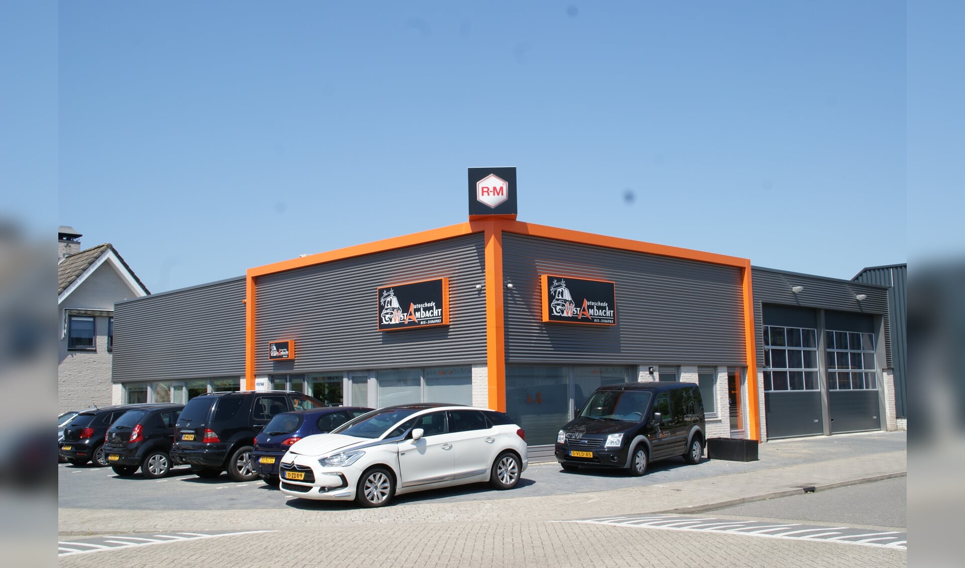 Het pand van Autoschade OostAmbacht, overduidelijk herkenbaar op het bedrijventerrein in Nootdorp.