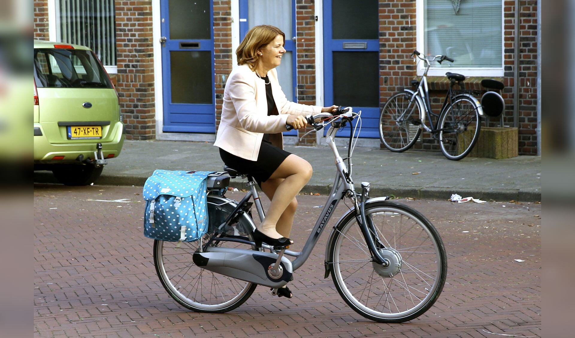Burgemeester Marja van Bijsterveldt, fietsend over de Kloosterkade, na een bezoek aan het buurthuis in de Wippolder. (foto: Koos Bommelé)