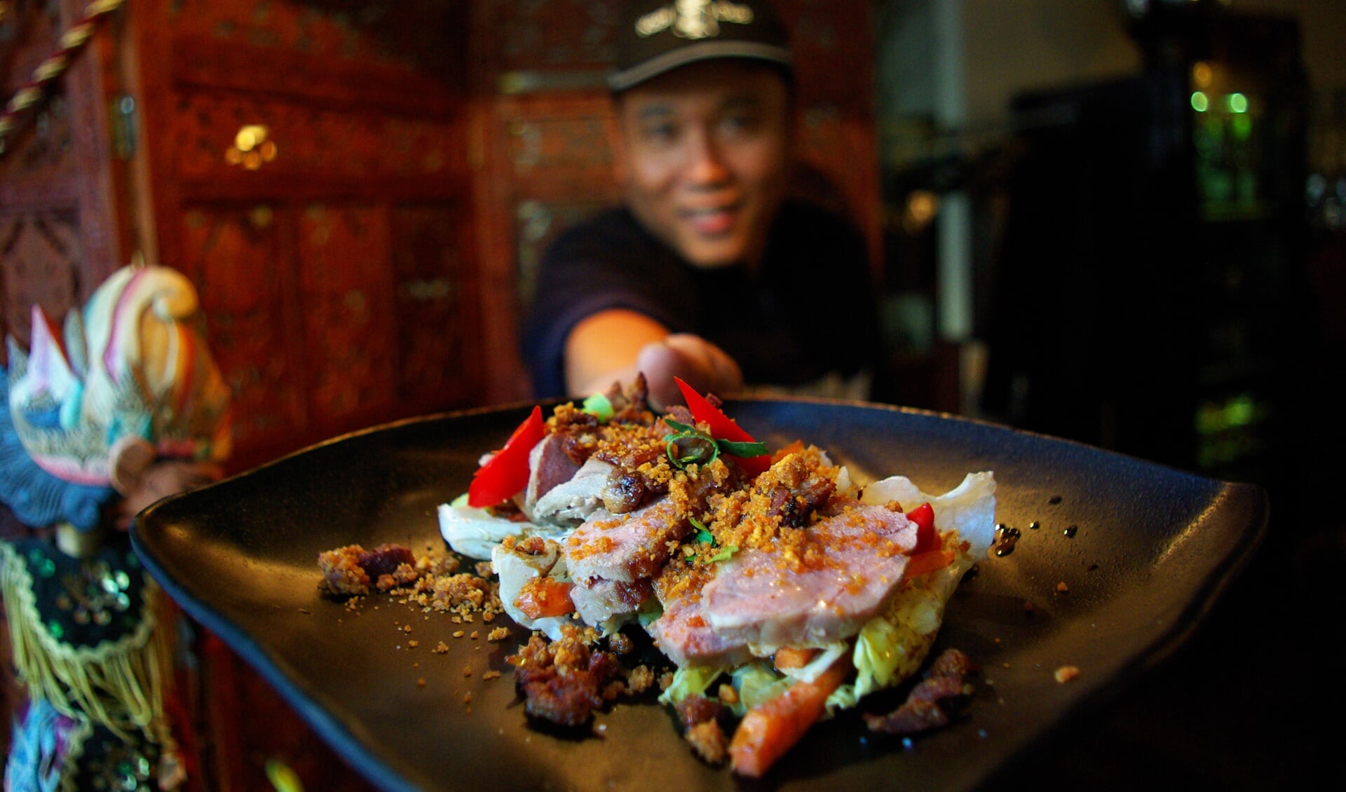 Chef-kok Hendri Yuswa showt één van de nieuwe voorgerechten: de salade eendenborst. 