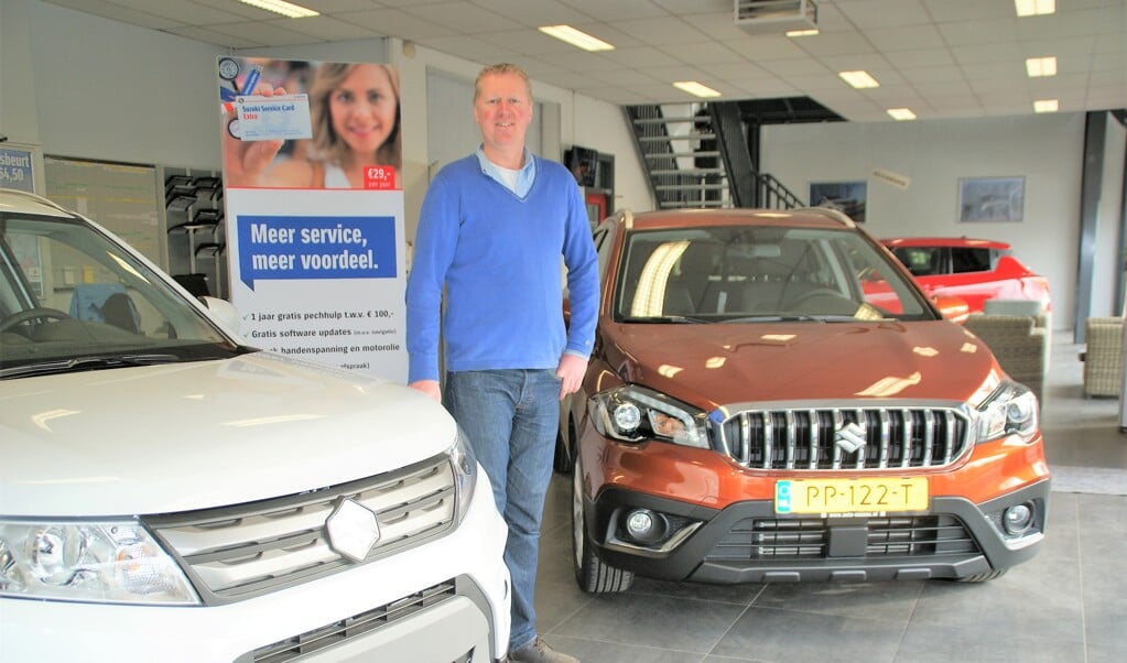 Patrick van den Berg bij links de Vitara en rechts de S-Cross in de showroom van Auto Nassau
