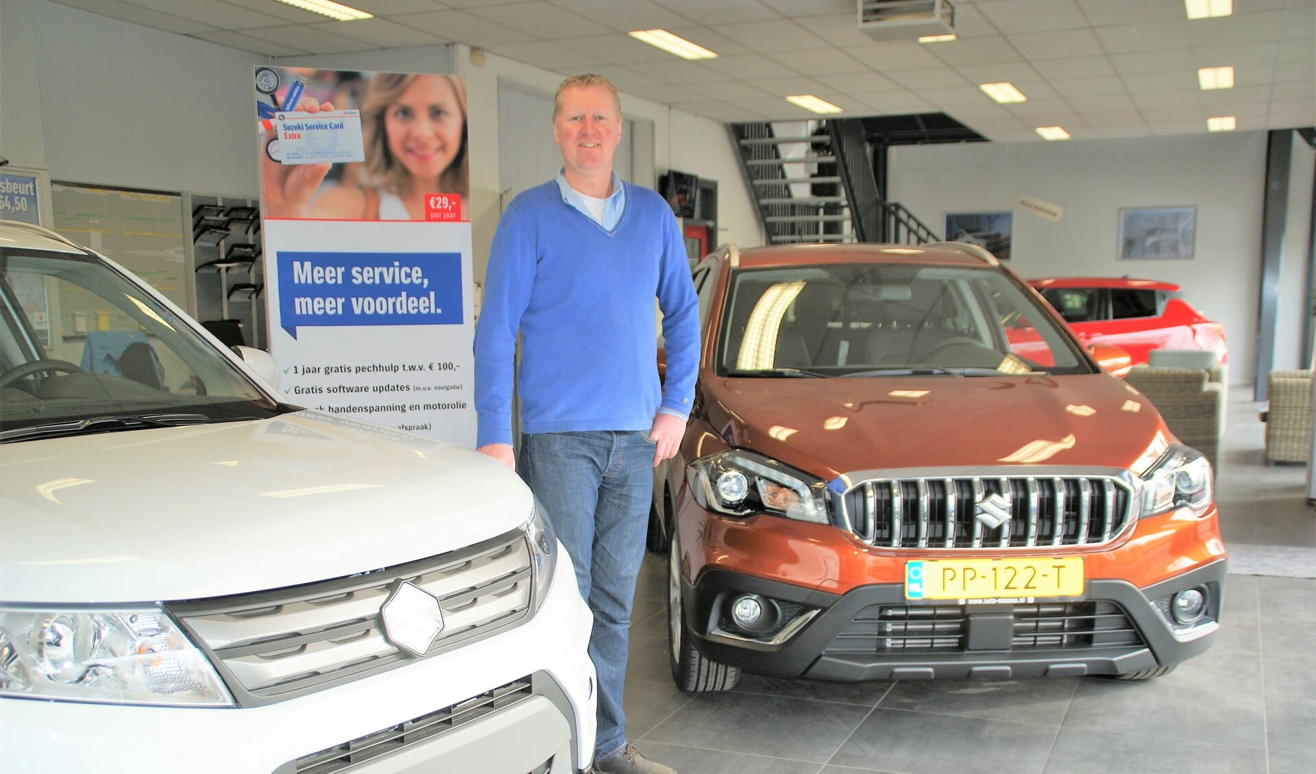 Patrick van den Berg bij links de Vitara en rechts de S-Cross in de showroom van Auto Nassau