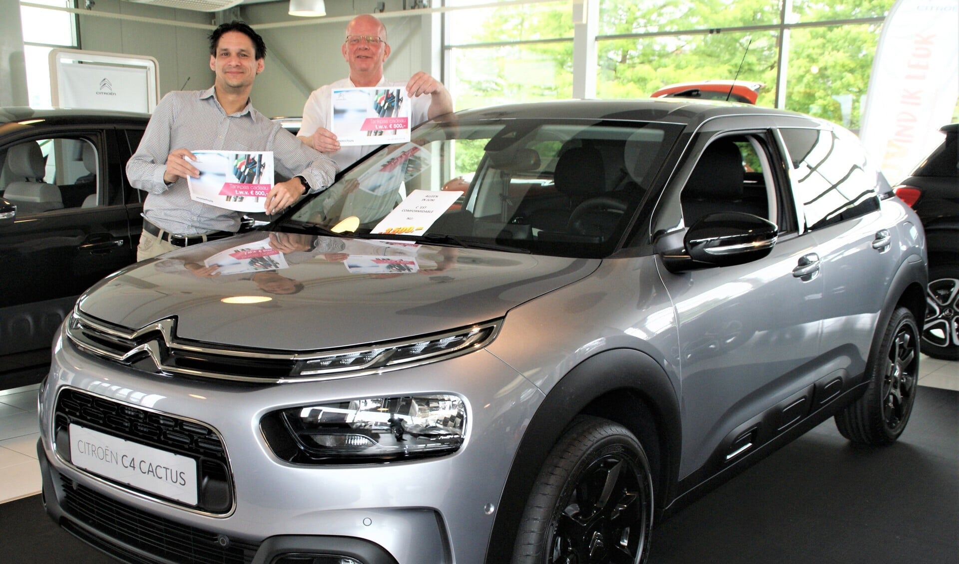 De verkoopadviseurs Roy Schaaij en Ben van Holsteijn, mèt tankpas, bij het actiemodel Citroën C4 Cactus.