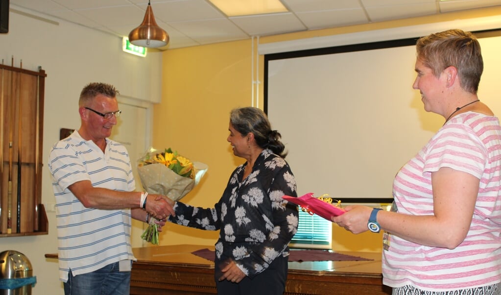 Jan Mostert overhadigt bloemen aan Iris Bandhoe, voorzitter van de Raad van Bestuur van GGZ Delfland. (Foto: EvE)