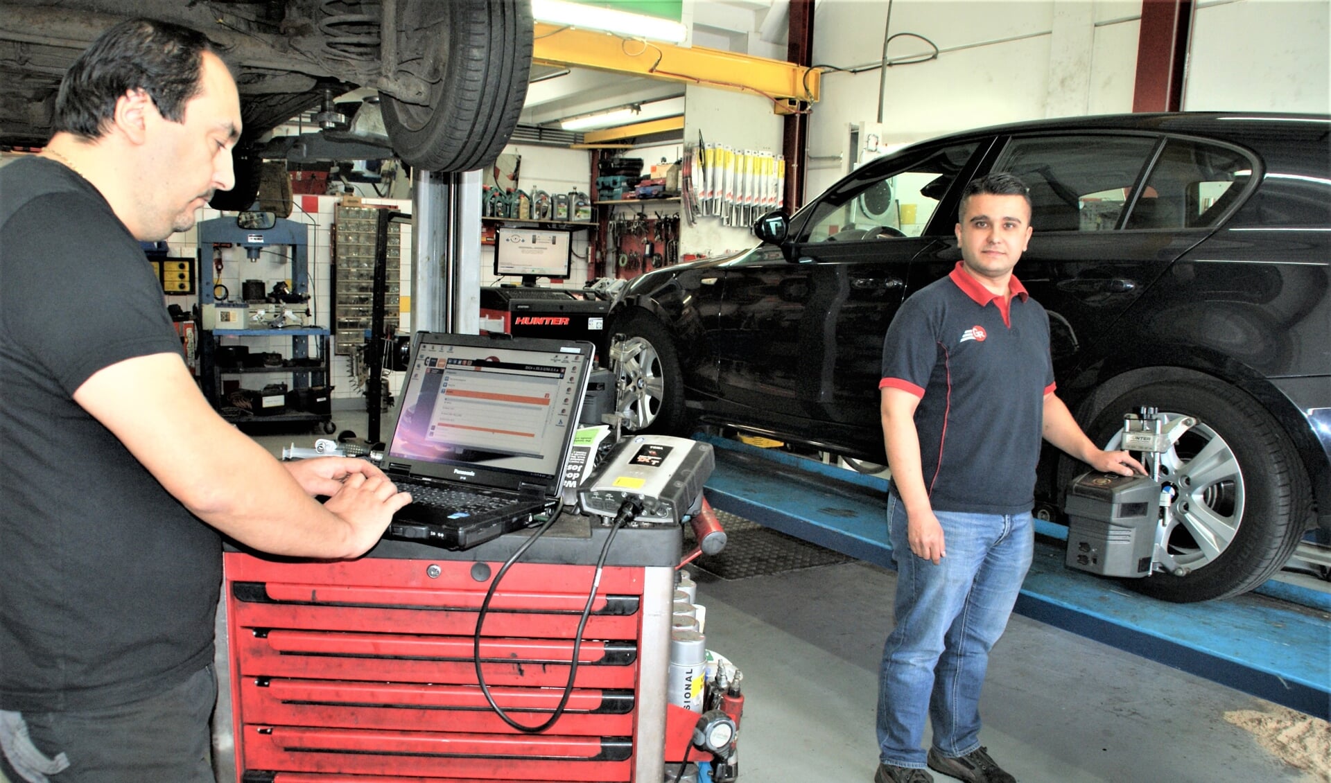 Mustafa (links) en Akif met de uitlijnapparatuur aan het werk in de werkplaats van Garage Randstad.