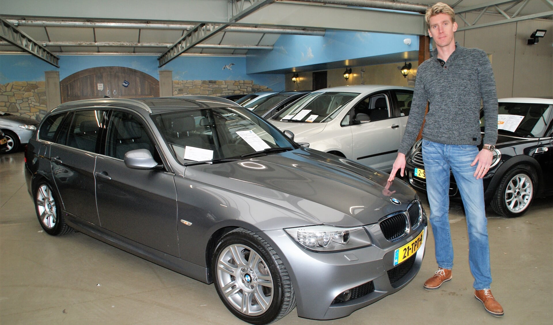 Verkoopadviseur Stefan van Steenderen bij de BMW 318i Touring M-sport Edition in nieuwstaat.