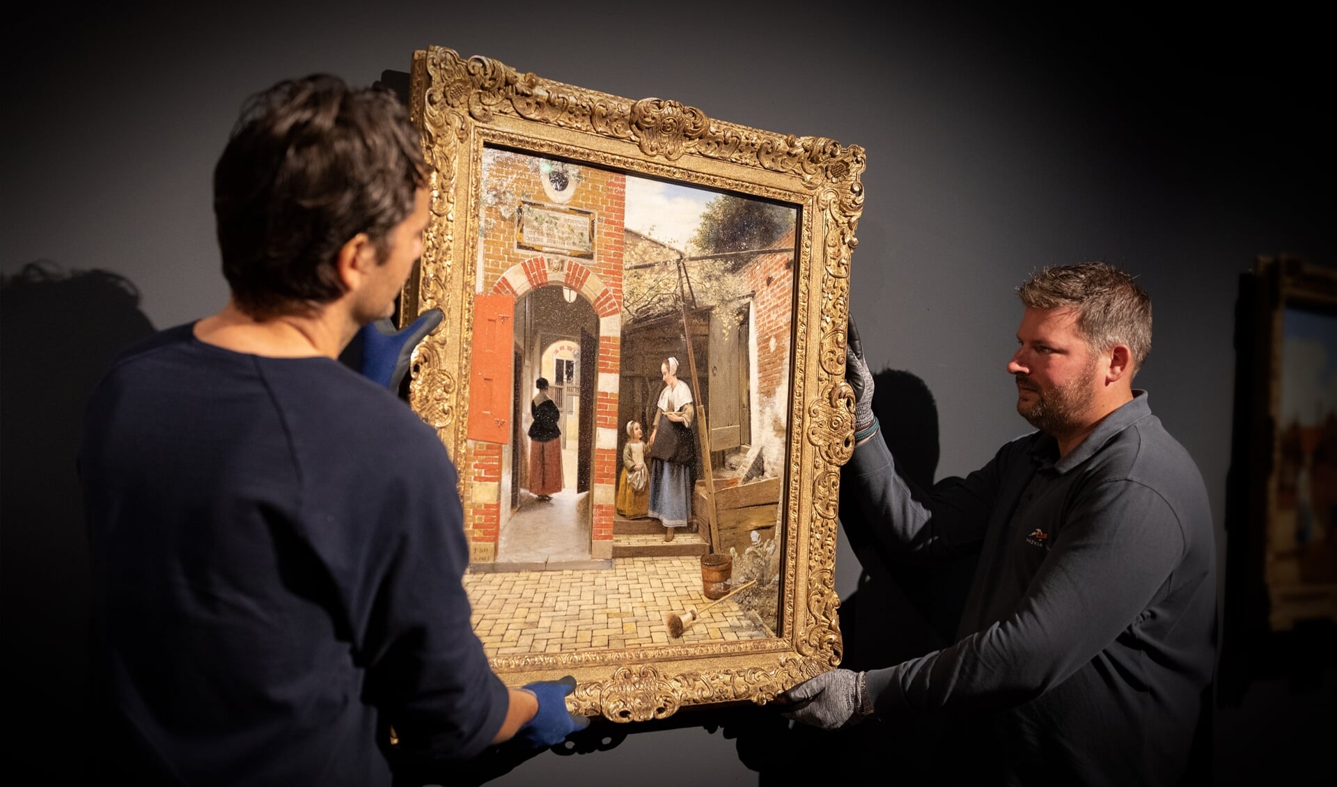 Art handlers installeren het beroemde schilderij Binnenplaats van een huis in Delft 