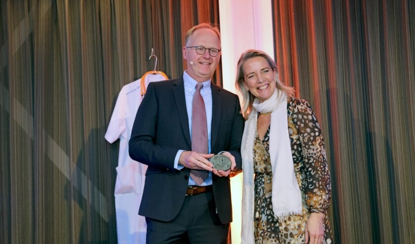 Kinderarts Nico van der Lely met de penning, overhandigd door directeur Carina Hilders