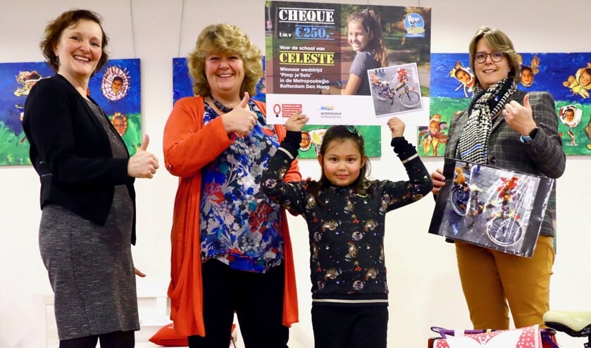 Celeste showt met trots de door haar gewonnen cheque. Links staat wethouder Huijsmans