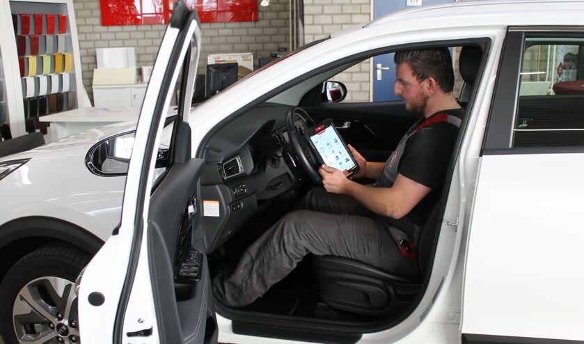 Medewerker Sjoerd Wijsman in de werkplaats bezig met het uitlezen van eventuele storingen in de auto-elektronica.