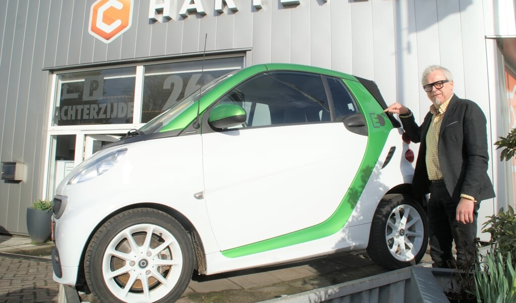 Directeur Leo Harteveld toont de Smart Fortwo Electric Drive bij de entree van zijn autobedrijf.