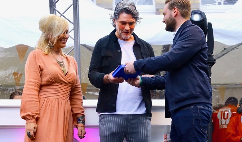 George Zevenbergen krijgt de Gouden Klinker overhandigd door wethouder Bas Vollebregt, gadegeslagen door Monique Zevenbergen (l.) (Foto; Koos Bommelé)