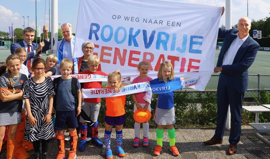 Voorzitter Peter van Haagen van Ring Pass showt, samen met de kleinste leden,vol trots de slogan. Ring Pass is de 1000e rookvrije sportvereniging in Nederland (Foto: Koos Bommelé)