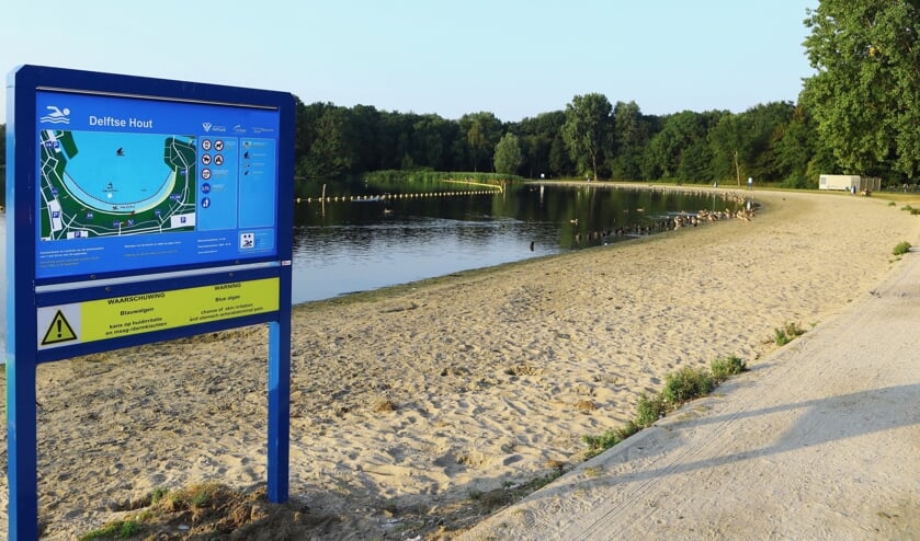 Het bord dat waarschuwt voor blauwalg in het water van De Delftse Hout