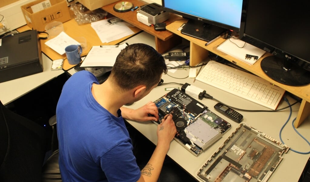 Rick is druk bezig met het repareren van een laptop. (Foto: EvE)