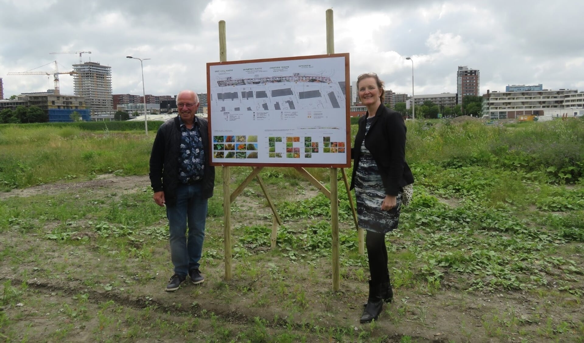 Frans Postma, namens buurtvereniging Delftzicht, en wethouder Huijsmans (rechts), tevens buurtbewoner, onthulden samen een bord met ideeën voor de verdere invulling van de parkstrook.
