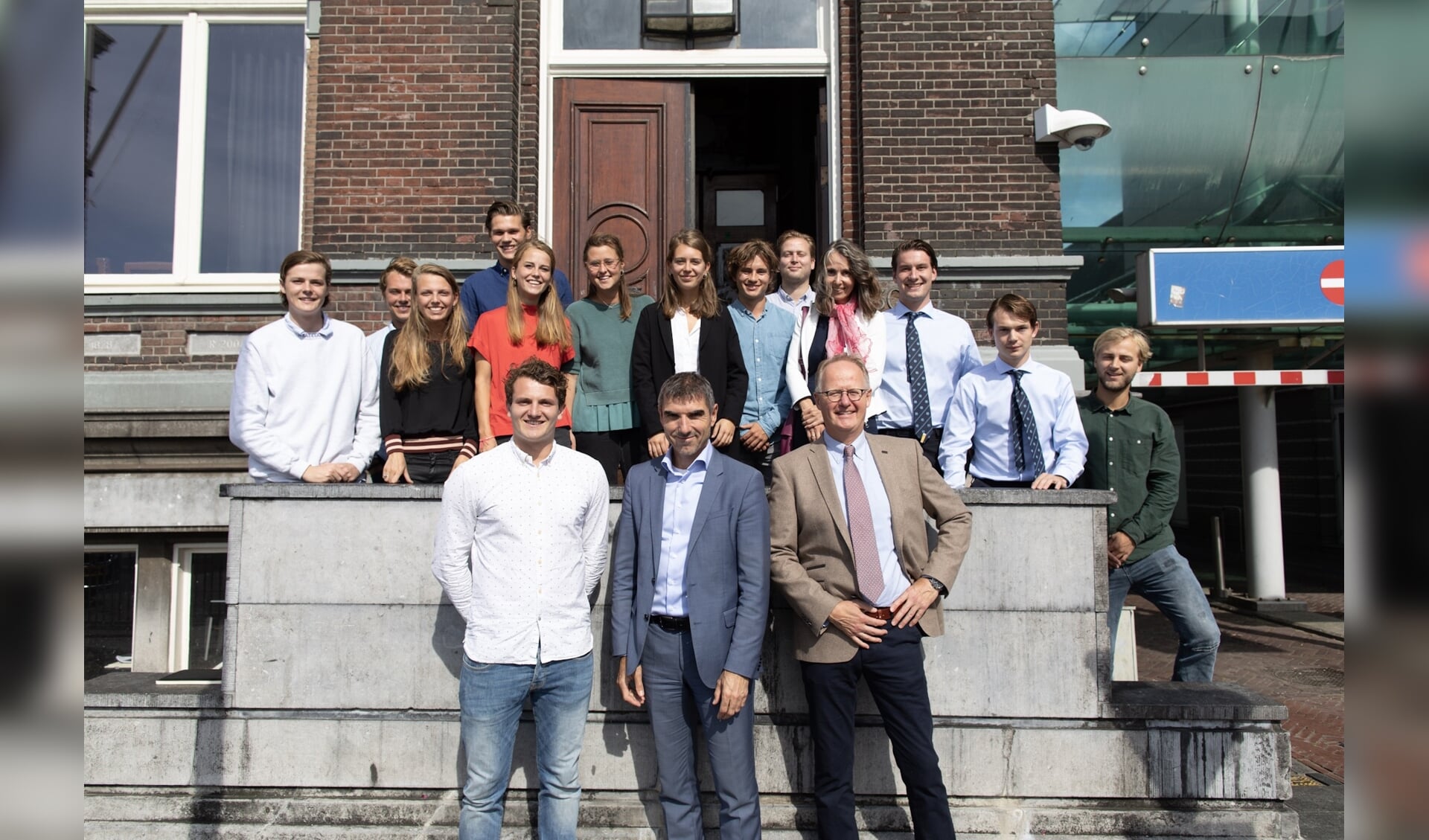 Staatssecretaris Paul Blokhuis (midden vooraan) en kinderarts Nico van der Lely (rechts vooraan) gingen op bezoek bij Delftse studenten