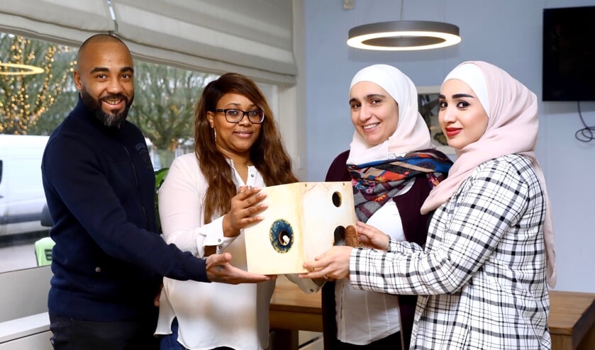 Jully Clemensia geeft de Doorkijker door aan Dima Akhras; Derrick Leeuwin en Sara Aljabi zijn getuige (Foto: Koos Bommelé)