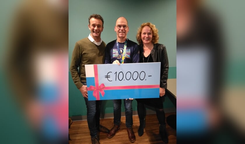 Nico Heijker overhandigd zijn donatie aan Peter Ausems en Irma van Gelderen
