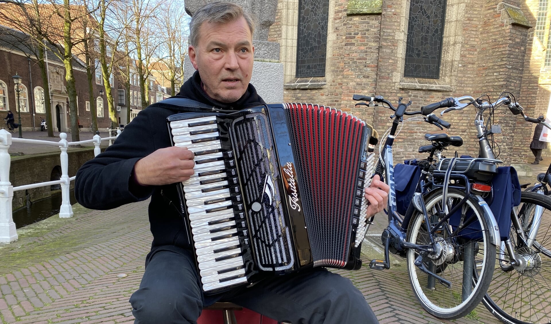 Tom van Geraas. Al tien jaar bespeelt hij zijn accordeon voor de Oude Kerk