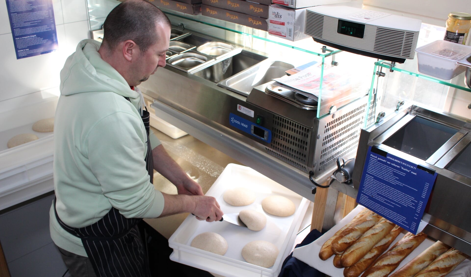 Jur is bezig met het 'openen'van het pizzadeeg, dat van speciaal volkorenmeel is gemaakt. (Foto: EvE) 