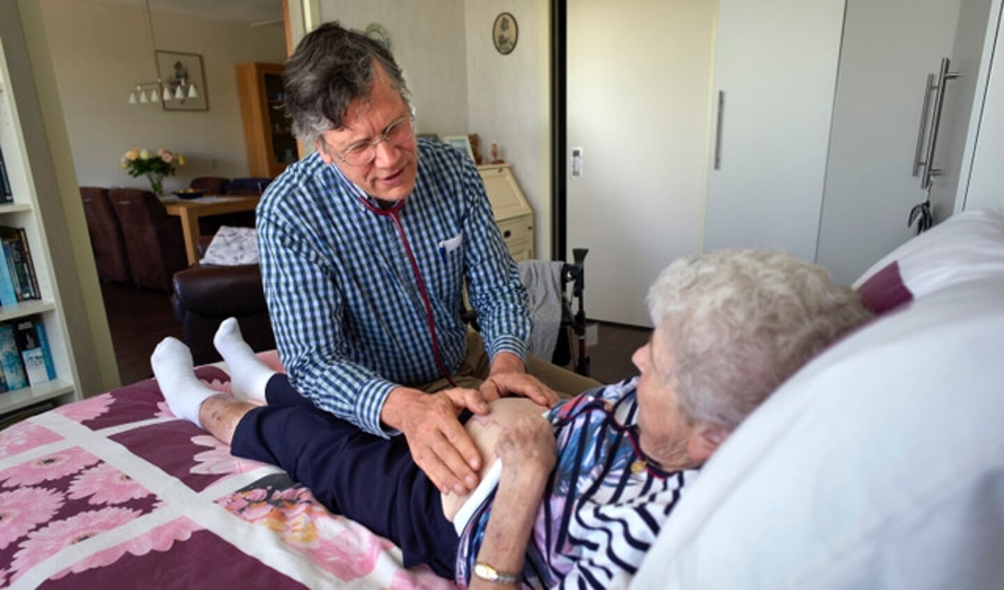 Huisarts Ferdinand Schreuder onderzoekt de buik van een oudere vrouw tijdens een visite (Foto: Roel Visser)